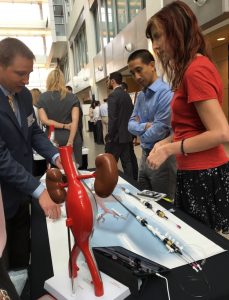 Aaron Santner demonstrates Cook products for FDA attendees Charlie Yongpravat and Valerie Merkle.
