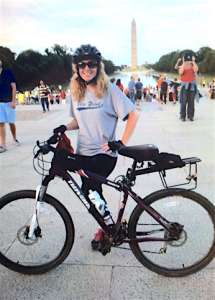 Donna poses for a photo a the Lincoln Memorial, with the Washington Monument visible across the National Mall. 