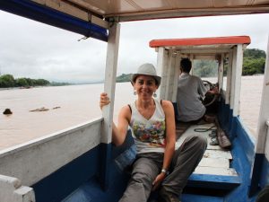 Rosa lounges on a boat traveling on the Mekong river in Southeast Asia.