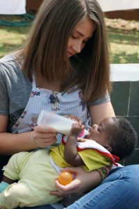 Vera holds a child who has regained health at the New Life Home.